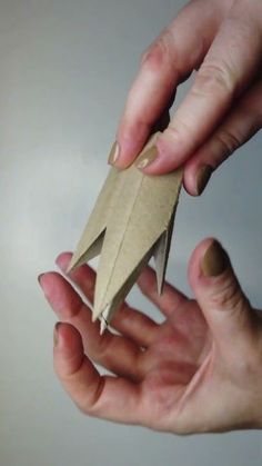 someone is holding an origami bird in their hand