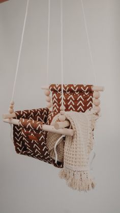 a baby's crib mobile hanging from the ceiling with wooden beads and tassels