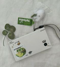 a white laptop computer sitting on top of a bed next to a green leafy plant