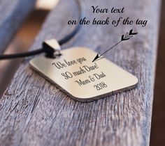 a necklace with the words strong on it sitting on a wooden table next to a cord