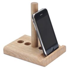 a cell phone is sitting on top of a wooden stand with holes in the wood