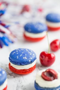 red, white and blue macaroons with cherries on the top are ready to be eaten