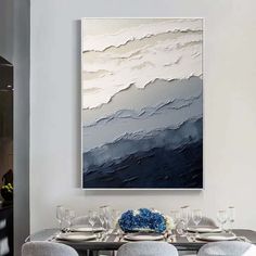 a dining room table with chairs and a large painting on the wall above it that has blue hydrangeas in front of it