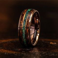 a wedding band with green and brown wood inlays