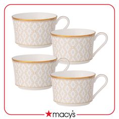 four white cups with gold trims on them