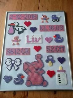 a cross stitch pattern on a white frame with pink and purple designs in the shape of hearts