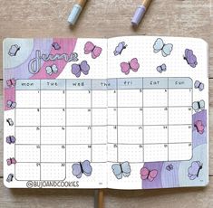 an open planner with butterflies on it next to some crayons and pencils