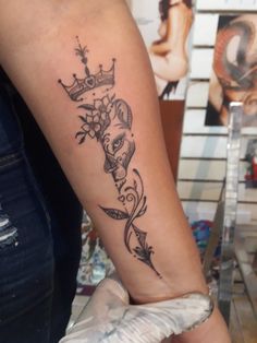 a woman's arm with a tattoo on it and a crown in the middle