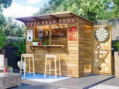 a small wooden bar set up in the middle of a yard with two stools next to it