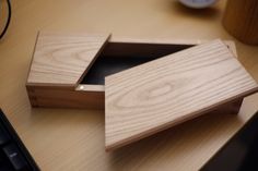 two pieces of wood sitting on top of a wooden desk next to a computer keyboard