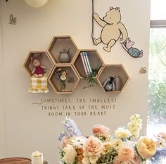 there are some shelves on the wall that have flowers in them and teddy bear figurines