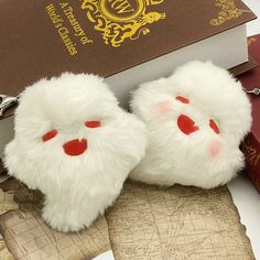 a pair of furry white slippers sitting on top of a book next to a keychain