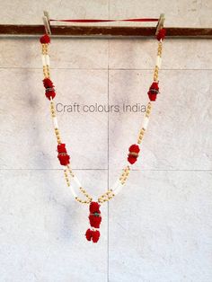 a white and red beaded necklace hanging on a wall