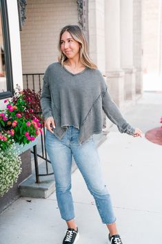 The Classic One Mineral Wash Long Sleeve Top is a casual, charcoal gray, waffle-knit top featuring a relaxed and effortlessly stylish design. The V-neckline adds a touch of femininity, while the exposed seams along the shoulders and sides give it a raw, edgy look. The top has a slightly oversized fit, perfect for layering or wearing on its own for a comfortable yet chic outfit. The waffle texture adds warmth and dimension, making this top an excellent choice for cooler days. Fabric: 53% Cotton 4 Gray V-neck Sweater For Spring Layering, Gray Textured Knit V-neck Top, Gray Waffle Knit Top For Fall, V-neck Waffle Knit Tops For Layering, Waffle Knit V-neck Tops For Layering, Loungewear Dresses, Exposed Seams, Waffle Knit Top, Chic Outfit