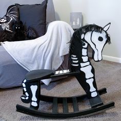 a rocking horse made to look like a skeleton on the floor next to a bed