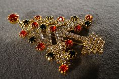 I am offering you this spectacular unique vintage gold tone bold 3 inches by 2 inch rhinestone Christmas tree pin brooch this pin has decorated with several completely covered beautiful round shaped multi colored, emerald green, ruby red, and clear white colored rhinestones, of this amazing Christmas tree pin brooch. Buyer pays all shipping and handling. Elegant Gold Christmas Brooches, Elegant Gold Brooches For Christmas, Gold Holiday Brooch Jewelry, Gold Christmas Brooches For Festive Occasion, Gold Jeweled Brooches For Party, Gold Christmas Brooches For Formal Wear, Gold Brooches For Formal Christmas Occasion, Gold Rhinestone Party Pins, Gold Rhinestone Pins For Party