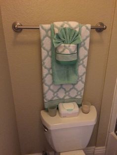 a white toilet sitting in a bathroom next to a towel rack