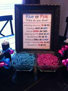 there is a sign that says blue or pink next to two containers with beads in them