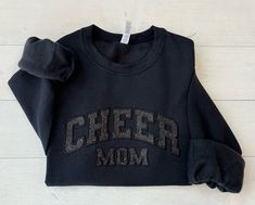 Elevate Your Cheer Spirit with Our Glitter Applique Embroidered Cheer Mom Sweatshirt! Showcase your pride and support for your cheerleader with our stunning Glitter Applique Embroidered Cheer Mom Sweatshirt. This stylish and cozy sweatshirt is designed for cheer moms who want to stay warm while looking fabulous at games and competitions. Key Features: Eye-Catching Design: The glitter applique adds a sparkling touch, making you stand out in the crowd. Premium Quality: Made from soft, durable fabr Cheer Mom Sweatshirt, Cheer Spirit, Christmas Catalogs, Jeans Leggings, Cozy Sweatshirts, Cheerleading, Stay Warm