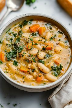 a white bowl filled with vegetable soup on top of a table