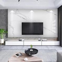 a modern living room with marble walls and white furniture, including a large flat screen tv on the wall