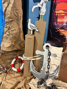 two wooden posts with chains and an anchor on them, sitting next to other items