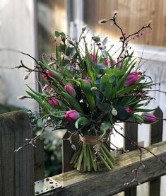 a bouquet of flowers sitting on top of a wooden fence