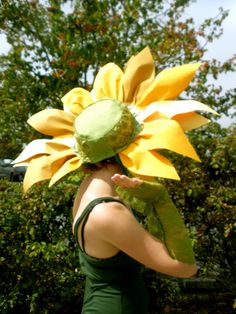 a woman wearing a sunflower hat and green dress