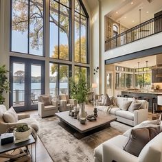 a living room filled with lots of furniture and large windows over the top of it