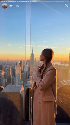 a woman standing on top of a tall building looking at the cityscape in the distance