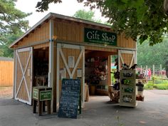 a small wooden building with a sign for a gift shop