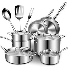 a set of stainless steel pots and pans with spatulas on white background