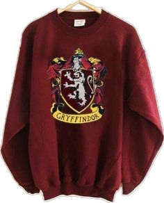 a harry potter sweatshirt hanging on a hanger with the words gryffindor