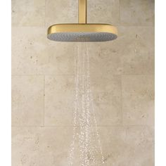 an overhead shower head with water running down it's side and the handles are gold