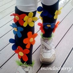 the legs and ankles of a person wearing colorful socks with flowers on them, standing on a wooden deck