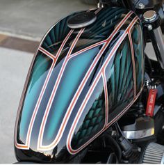 a close up view of the side of a motorcycle with decorative stripes and curves on it