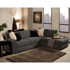 a living room filled with lots of furniture next to tall windows and a rug on the floor