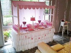 a table that has some cake on it and balloons hanging from the ceiling above it