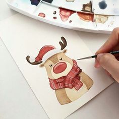 someone is painting a reindeer with watercolors on paper