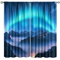 the curtains are open to show an image of mountains and aurora lights in the sky