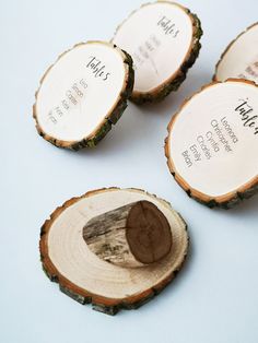 four pieces of wood that have been cut into slices with names on them, and one has a wooden slice in the middle