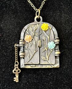 a necklace with flowers and keys hanging from it's front door, on a black surface