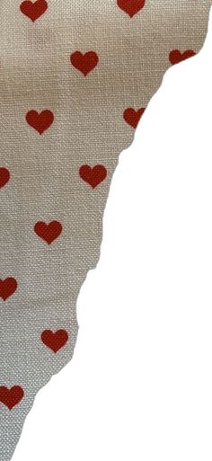 a piece of cloth with red hearts on it and a white background that is cut in half