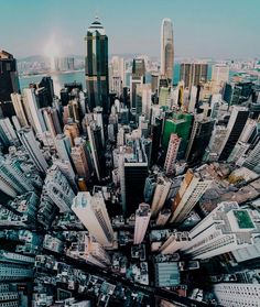 an aerial view of a city with lots of tall buildings and water in the background