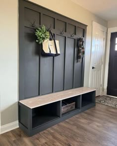 the entryway is decorated in black and has a bench with two hooks on it