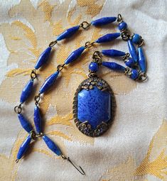 Unique and beautiful vintage art deco Czech blue art glass choker pendant. The brass link chain adorned with glass beads features a 1 inch wide 1.5 inch long statement sized dangle of cobalt blue glass set in an ornate filagree setting embellished with four blue cut crystals prong set and fastened with a delicate hook. At 16 inches, it calls for someone of slim neck. A truly spectacular antique piece of lovely patina and in excellent condition! An exquisite birthday, anniversary, special occasion antique jewelry gift idea.  Thanks for looking and please feel free to follow my shop and checkout my selection of authentic vintage jewelry finds!  https://avintagerendezvous.etsy.com Camphor Glass Jewelry, Edwardian Necklace, Slim Neck, Czech Jewelry, Czech Glass Jewelry, Authentic Art, Cobalt Glass, Filigree Jewelry, Choker Pendant