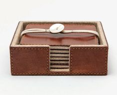 a brown leather box with a white button on it