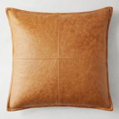 a brown leather pillow on a white wall