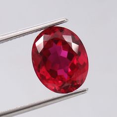 a red diamond is being held by two needles