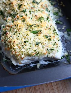 a piece of fish covered in cheese and parmesan sprinkled with herbs